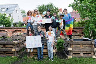 Schüler vor den selbstgebauten Hochbeeten.